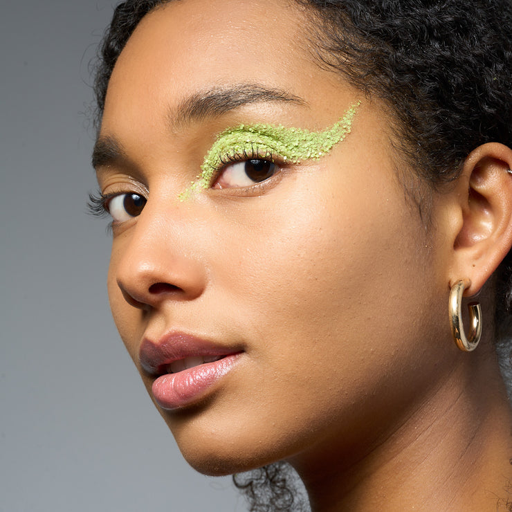 Neon grünes Bioglitzer vom Model getragen im Gesicht auf den Augen Makeup 