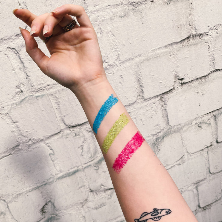 Nachhaltiger Ökoglitzer in Neon auf dem Arm Geschminkt